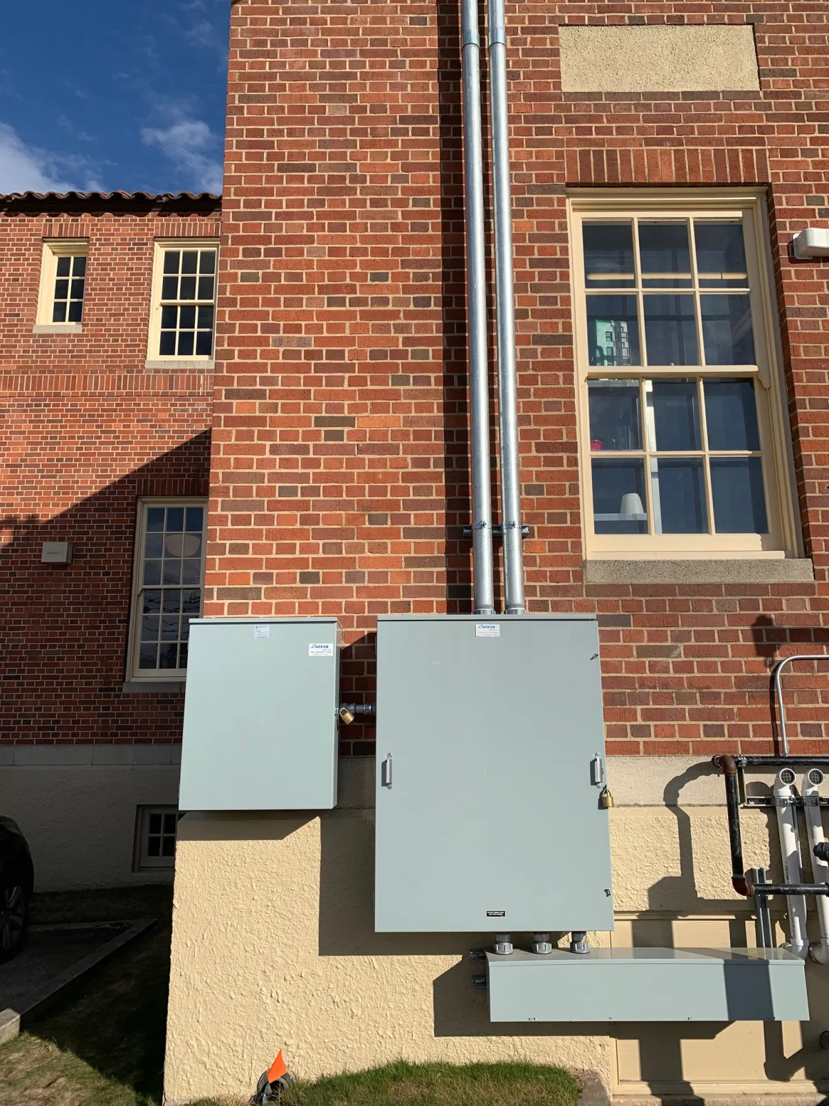 Finished exterior electrical service gear on MickDuff's restored brick building at golden hour